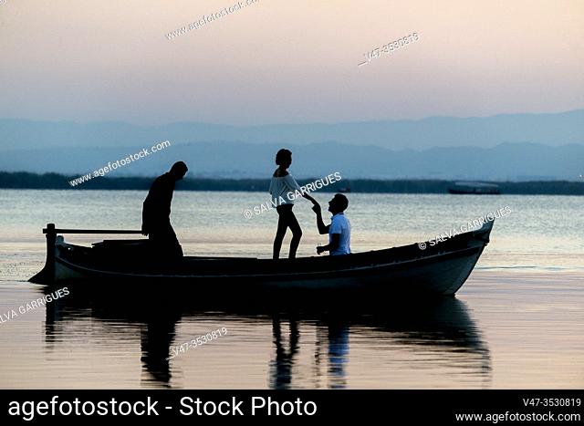 Moment in which the kneeling groom asks the bride to marry a boat in the Albufera of Valencia at the time the sun goes down, Spain