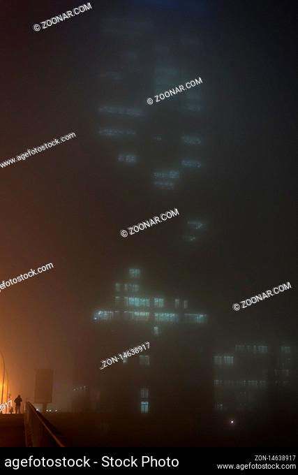 A skyscraper in dense fog in Berlin in portrait format