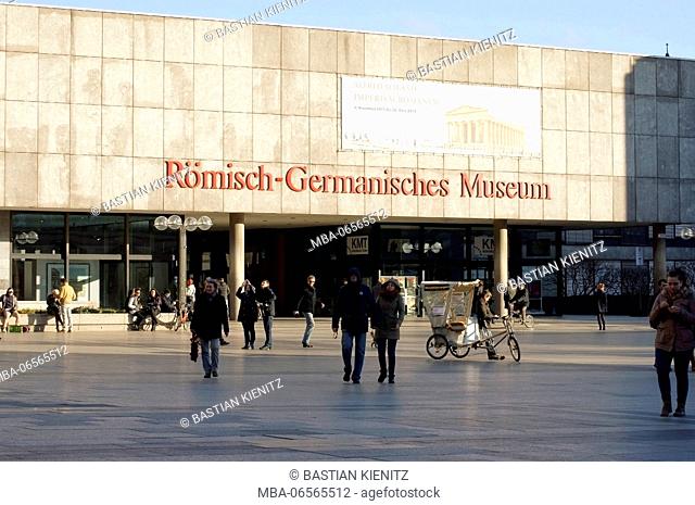 Tourists, travellers and a bicycle rickshaw in front of the Roman Germanic museum in Cologne
