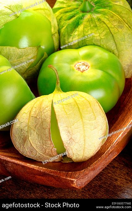 Tomatillos, green tomatoes, Mexican food ingredient on a dark rustic wooden background, a close-up
