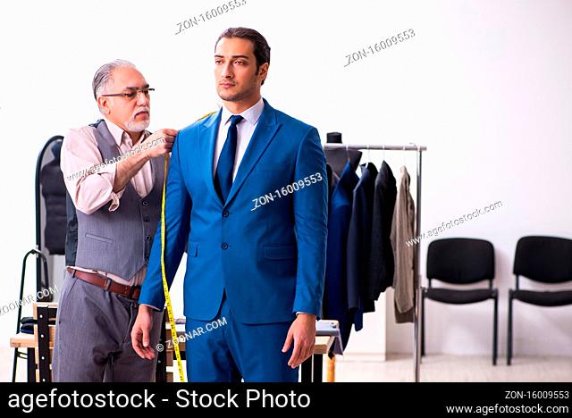 Young businessman visiting old tailor