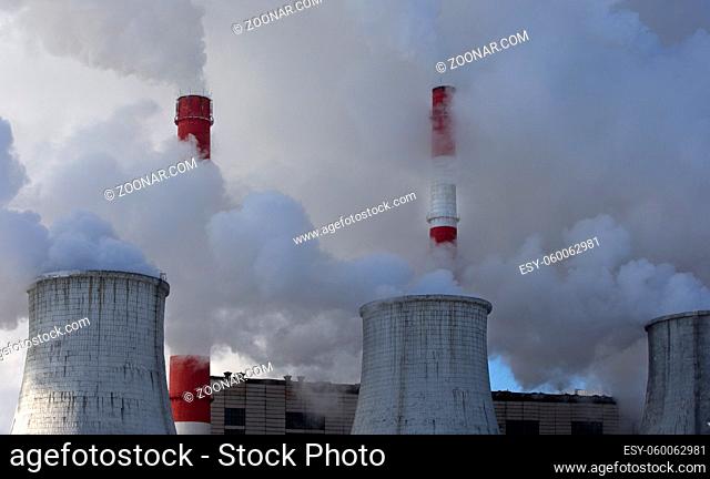 smoking chimneys of power plant in strong steam