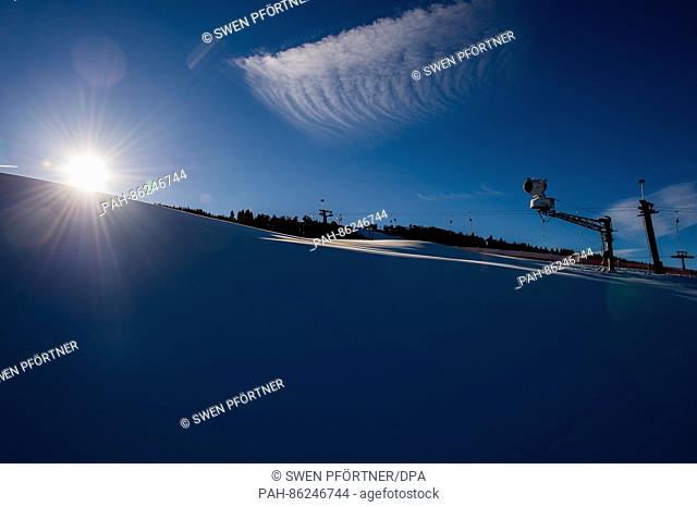 The sun shines down on a ski slope covered with artificial snow on the Ettelsberg mountain, which is situated in the Rothaar mountains near Willingen, Germany