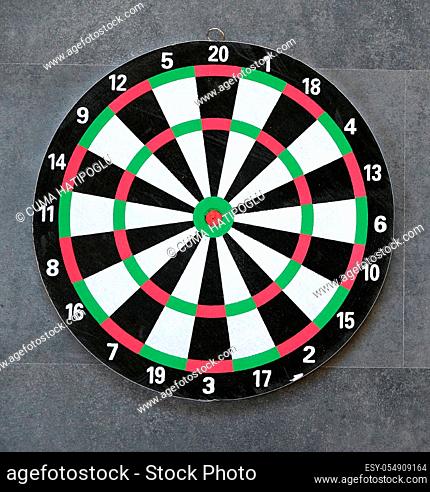 dartboard and dart arrows standing on black groundbdart arrow stuck and dart board