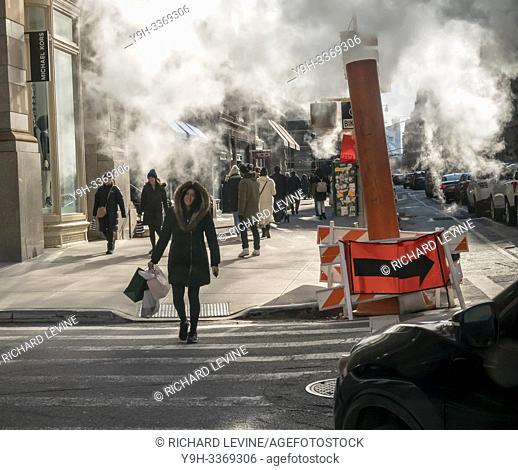 Pedestrians walk through Con Edison venting excess steam in the Flatiron neighborhood of New York on a cold winter Saturday, February 9, 2019