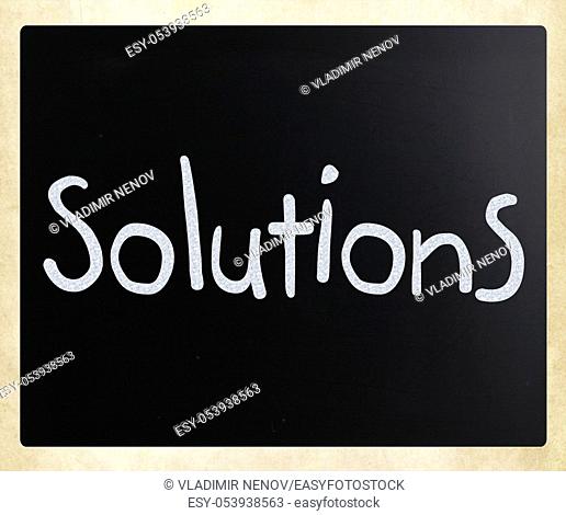 """""Solutions"" handwritten with white chalk on a blackboard