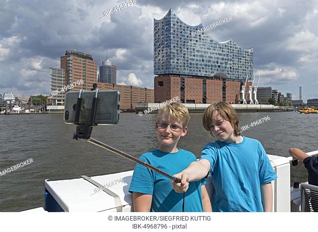 Young people making selfie in front of the Elbe Philharmonic Hall, Hamburg, Germany, Europe
