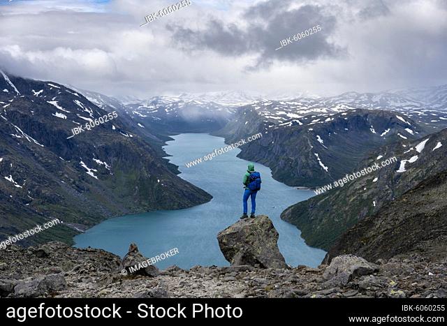 Hiker stands on rocks, Besseggen hike, ridge walk, Lake Gjende, Jotunheimen National Park, Vågå, Innlandet, Norway, Europe