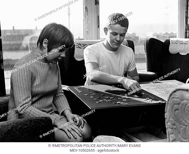 Two young Met Police colleagues at work on a jigsaw puzzle at the Convalescent Police Seaside Home at 205 Kingsway, Hove, East Sussex