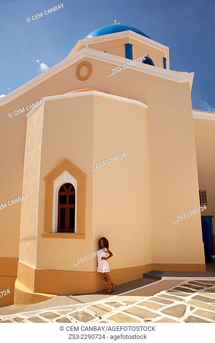 Woman standing in front of a colorful church in Hora, Serifos, Cyclades Islands, Greek Islands, Greece, Europe