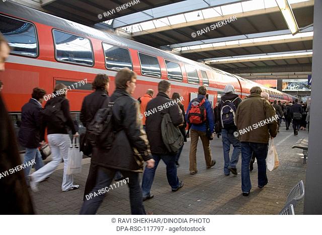 Eurail railway station ; passengers walking on the platform red train standing ; DB Hauptbahnhof main station ; Frankfurt ; Germany ; Europe