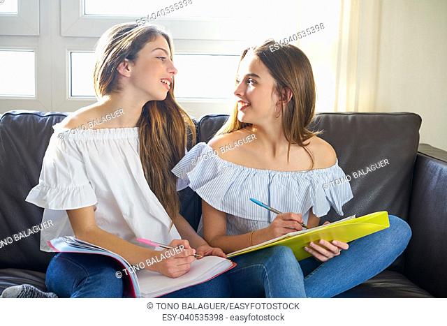 best friend girls studying homework at home in sofa