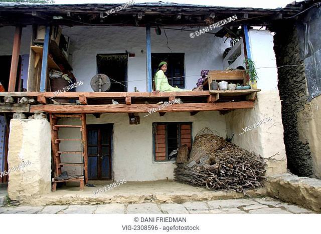 INDIA, BRAHN, 02.07.2010, A Hindu Rajput woman sits on the main level of her traditional mud home in Himachal Pradesh. These three-story homes are typical and...