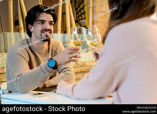 Man raising toast with girlfriend at restaurant