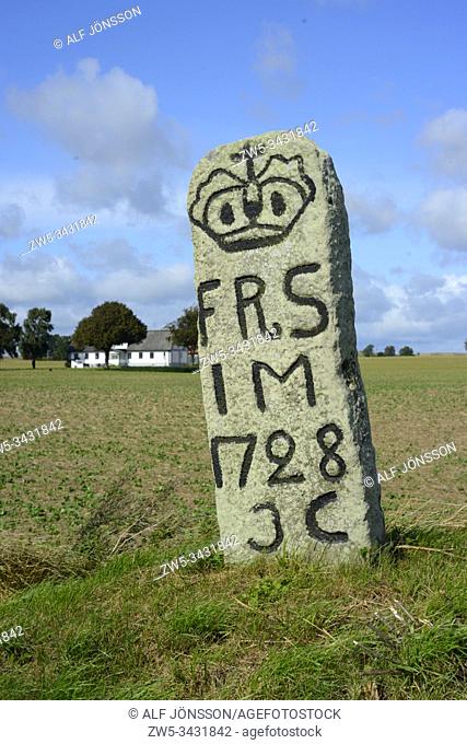 Old milestone on a country road in Scania, Sweden
