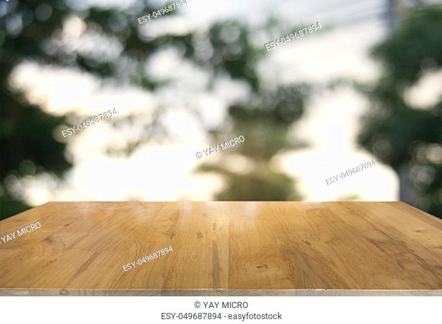 image of wooden table in front of abstract blurred background of outdoor garden lights. can be used for display or montage your products