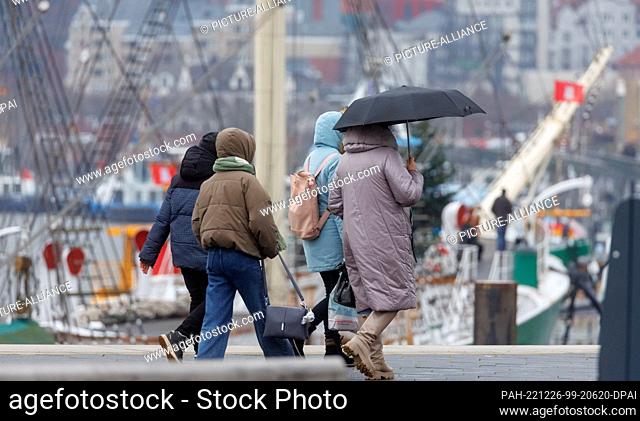 26 December 2022, Hamburg: Passers-by walk on the Baumwall flood protection site in changeable weather on Boxing Day. Photo: Markus Scholz/dpa