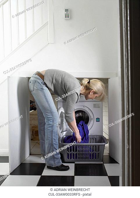 Woman unloading clothes from dryer