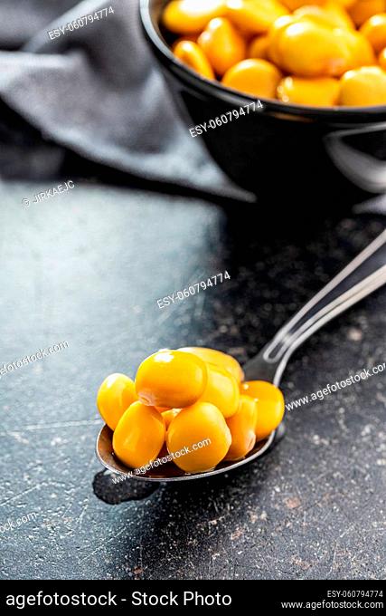 Pickled yellow Lupin Beans in spoon on kitchen table