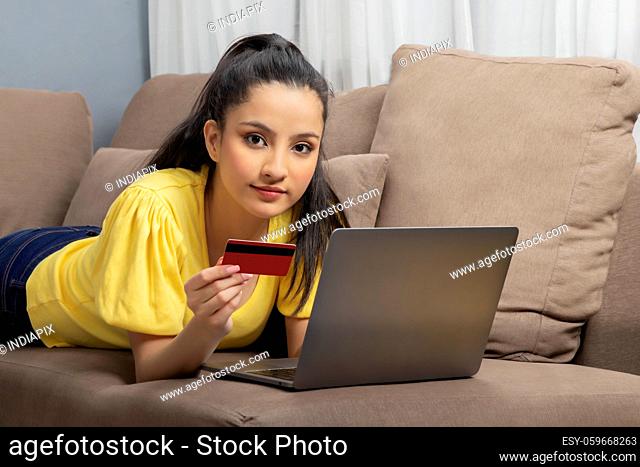 A young woman with laptop and credit card shopping online