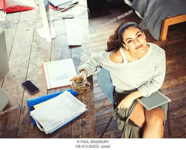 Portrait confident college student studying with tea and digital tablet