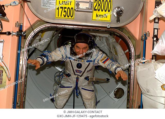 Cosmonaut Valery G. Korzun, Expedition Five mission commander, wearing a Russian Sokol suit, floats through a hatch into the Unity node on the International...