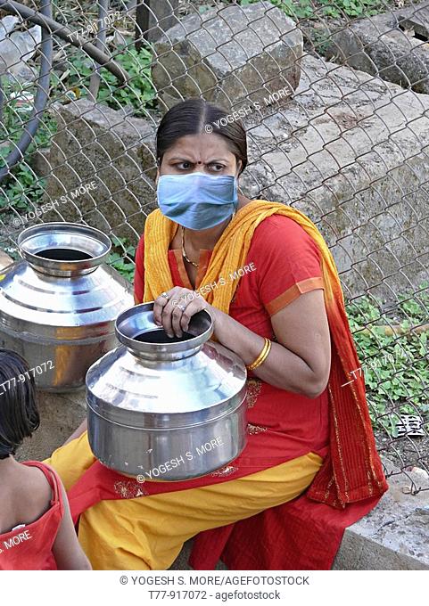 A woman at community water tap with mask, H1N1, India