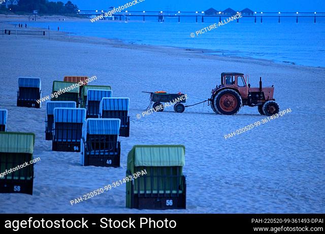 20 May 2022, Mecklenburg-Western Pomerania, Ahlbeck: One of the last beach fishermen drives to his boat in the morning before sunrise with an old tractor and...