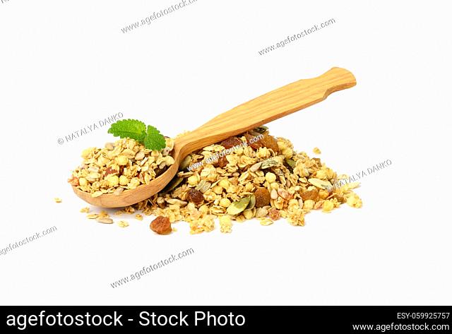 bunch of oatmeal crunches with raisins, pumpkin seeds and sunflower seeds. Wooden spoon on top