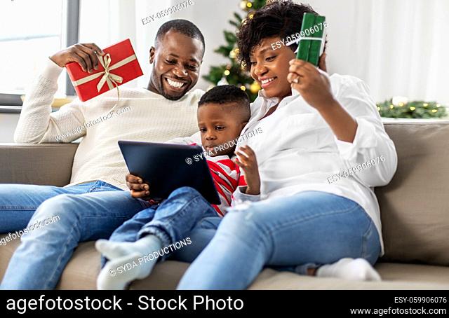 happy family with tablet pc and gifts on christmas