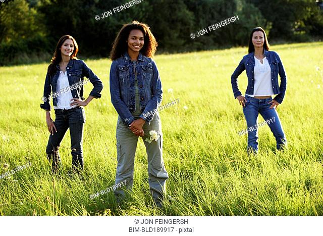 Three women standing in meadow