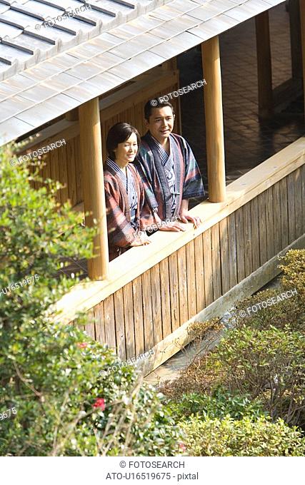 Mature Adult Couple Looking Outside From the Wooden Hallway, Side View, High Angle View, Waist Up