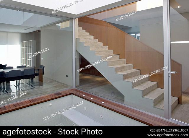 View through floor to ceiling windows to contemporary staircase and dining room