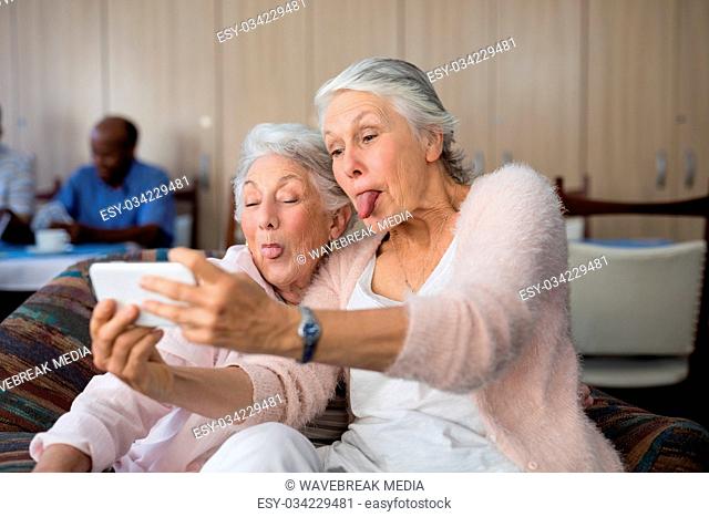 Senior women making face while taking selfie