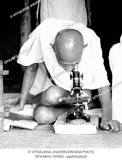Mahatma Gandhi and hospital assistant Shankaranji at the microscope observing leprosy germs at Sevagram Ashram , c 1942 NO MR