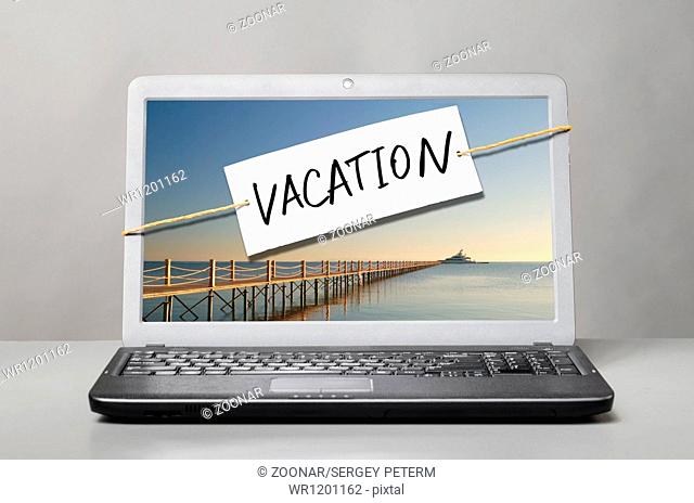 laptop with vacation note