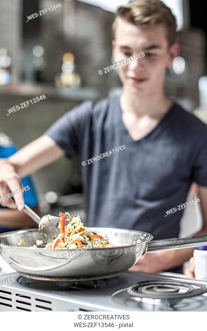 Teenager cooking on stove