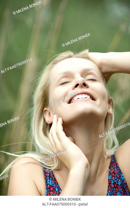 Yong woman smiling with face turning upwards
