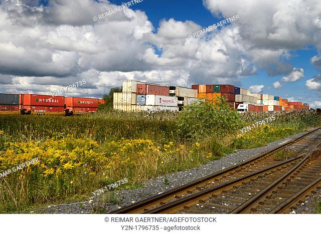 Multimodal transport containers stacked at a rail depot for delivery by truck