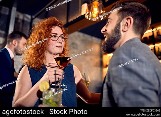 Couple with drinks talking in a bar