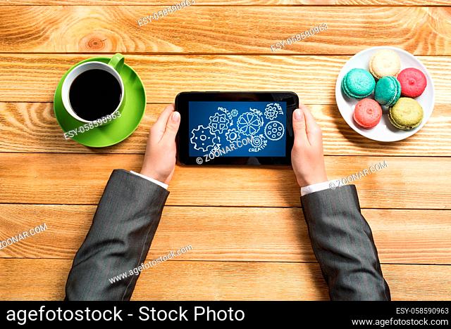 Top view of businesswoman sitting at table and using tablet
