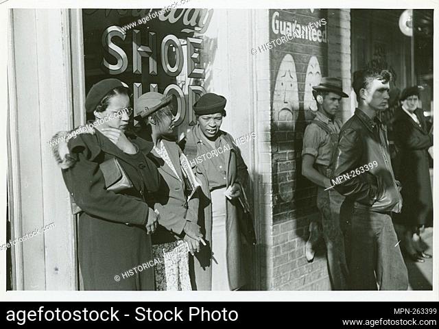 Domestic servants waiting for street car on way early in the morning. Mitchell Street, Atlanta, Georgia, May 1939. Additional title: [Three African American...