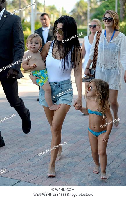 Kourtney Kardashian wears a white one piece swimsuit and denim hotpants as she takes her kids to the beach in Miami Featuring: Kourtney Kardashian, Reign Disick