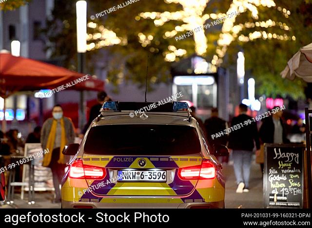 31 October 2020, North Rhine-Westphalia, Bochum: A police car drives through the Bermuda3eck nightlife district. Federal and state governments have decided on a...