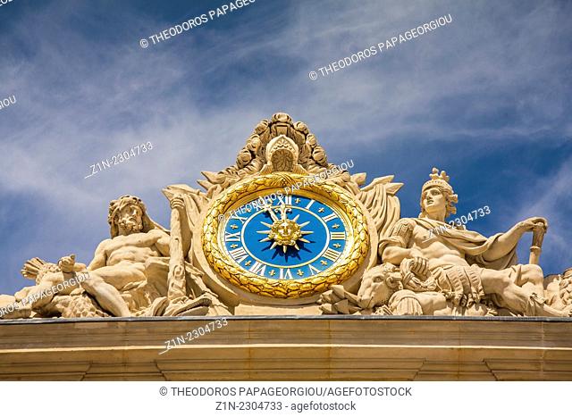 The clock and sculpture of Hercules above the main entrance to the Palace of Versailles, France