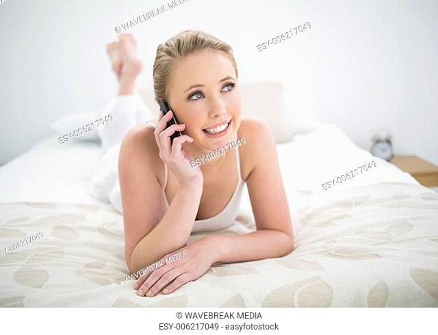 Natural content blonde lying on bed and phoning