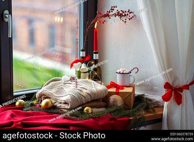 close up of sweater and christmas decor on sill