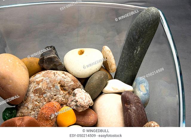 multicolored decorative pebbles in glass containers on a black background