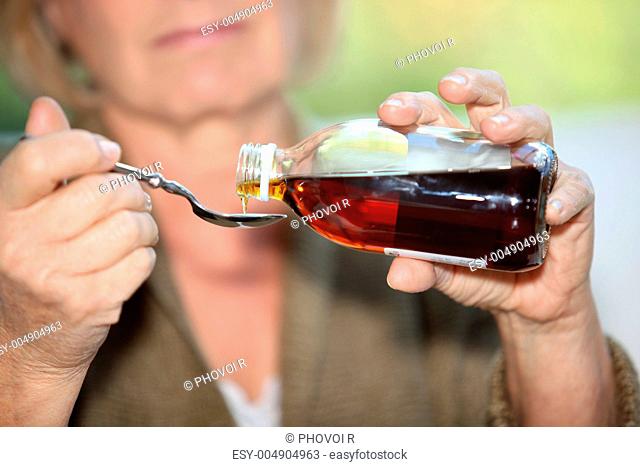 Woman taking cough medicine