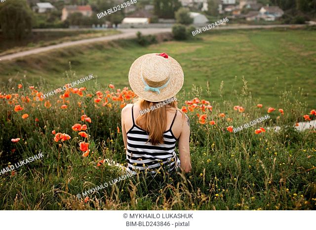 Caucasian woman sitting in wildflowers